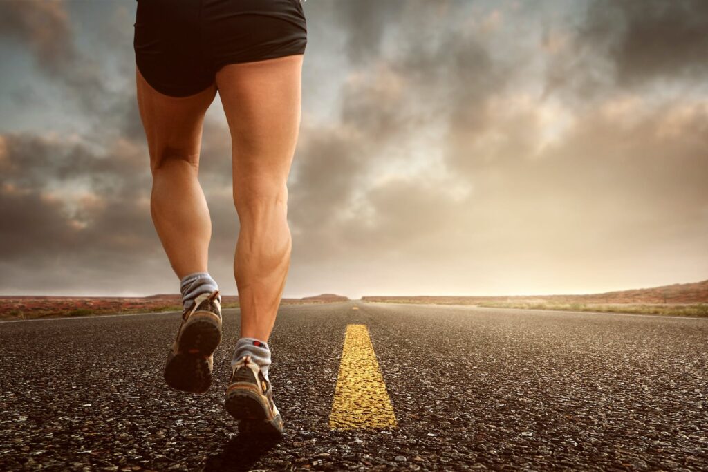 low angle photography man walking on asphalt road