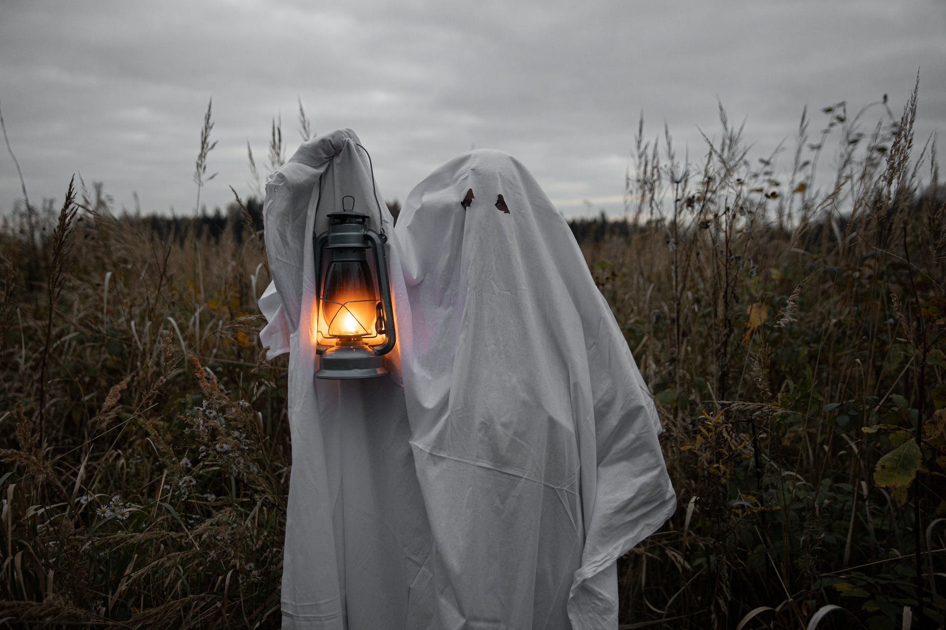 personin ghost costume holding a lantern