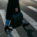 person carrying bag walking on pedestrian lane